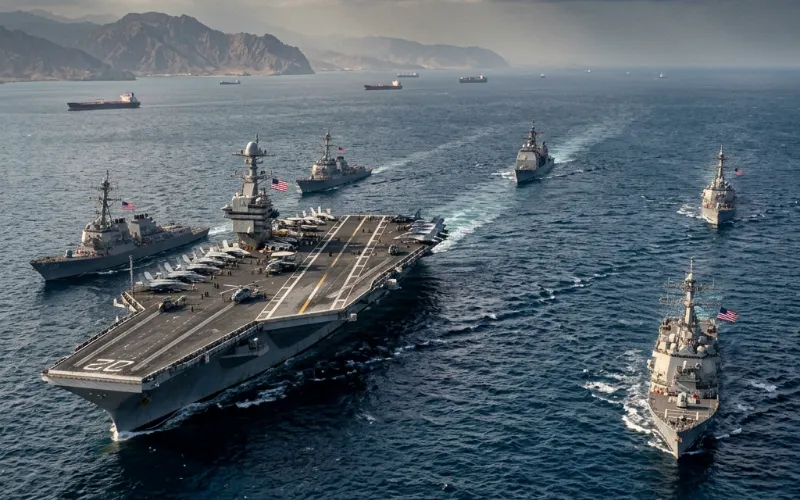An aerial view of a U.S. Navy aircraft carrier and escort warships patrolling the waters near the Strait of Hormuz.